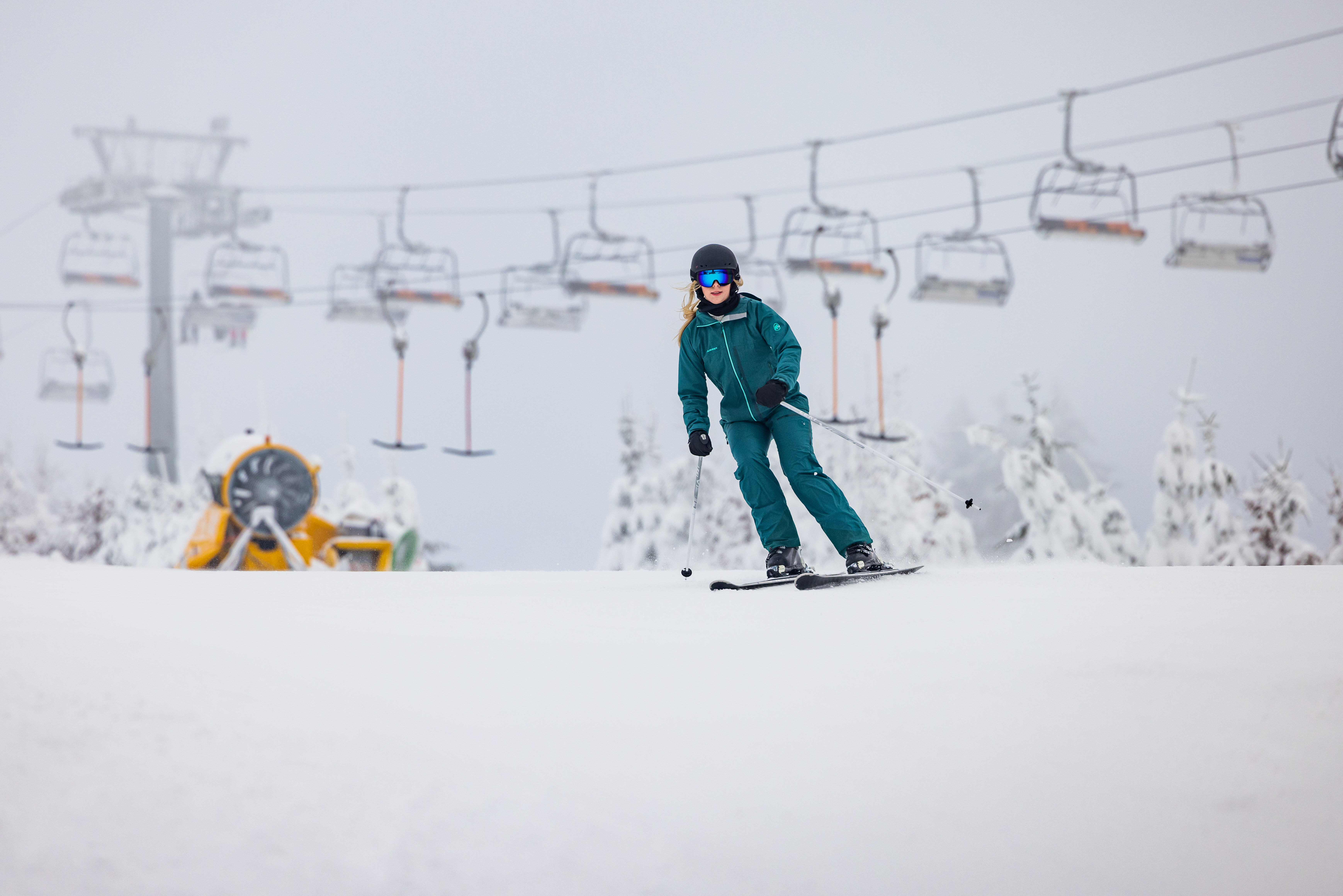 Ein Skifahrer auf der Piste mit Sessellift im Hintergrund..de-05.jpg