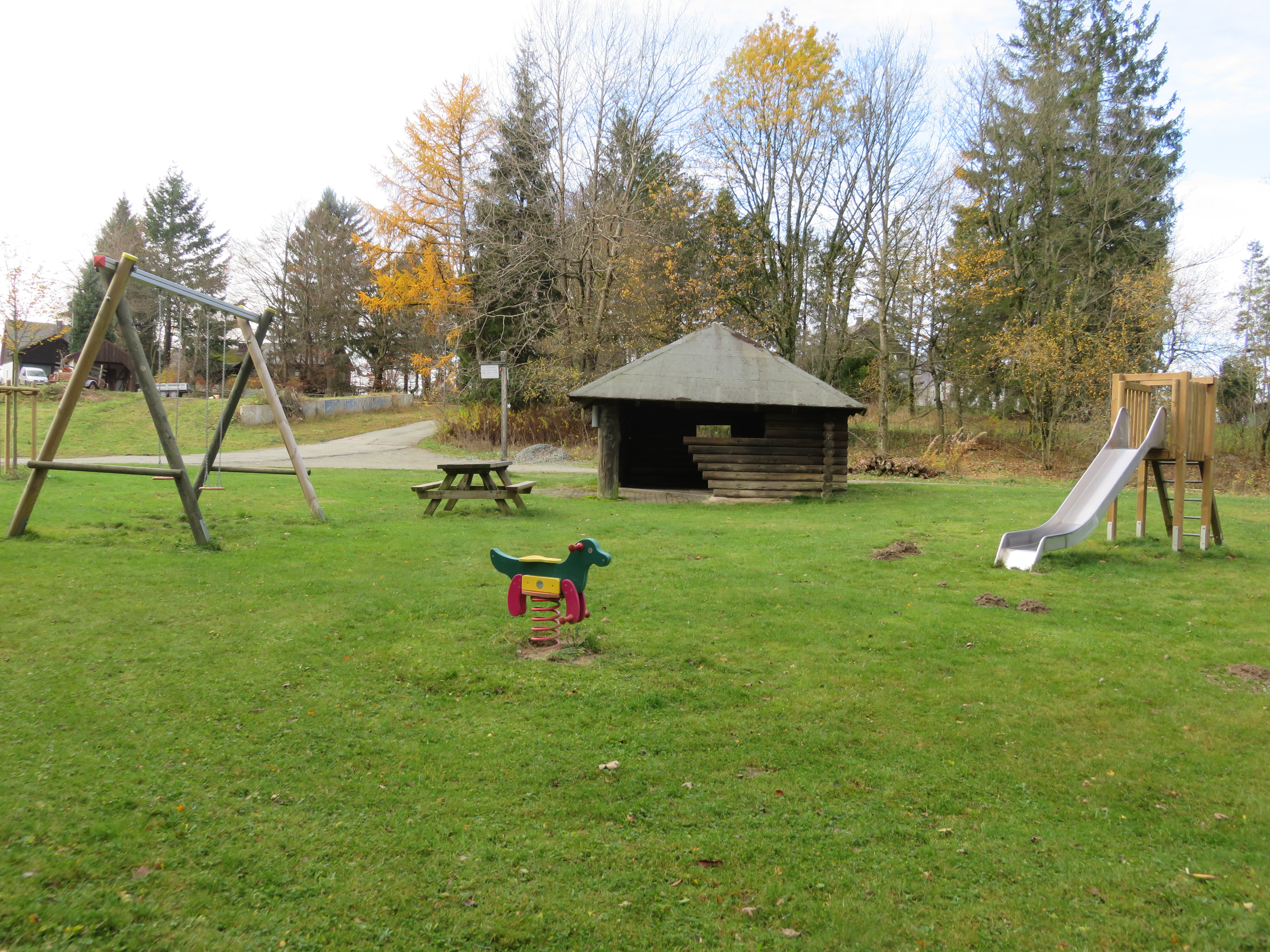 Spielplatz mit Schaukel, Rutsche und Wipptier.