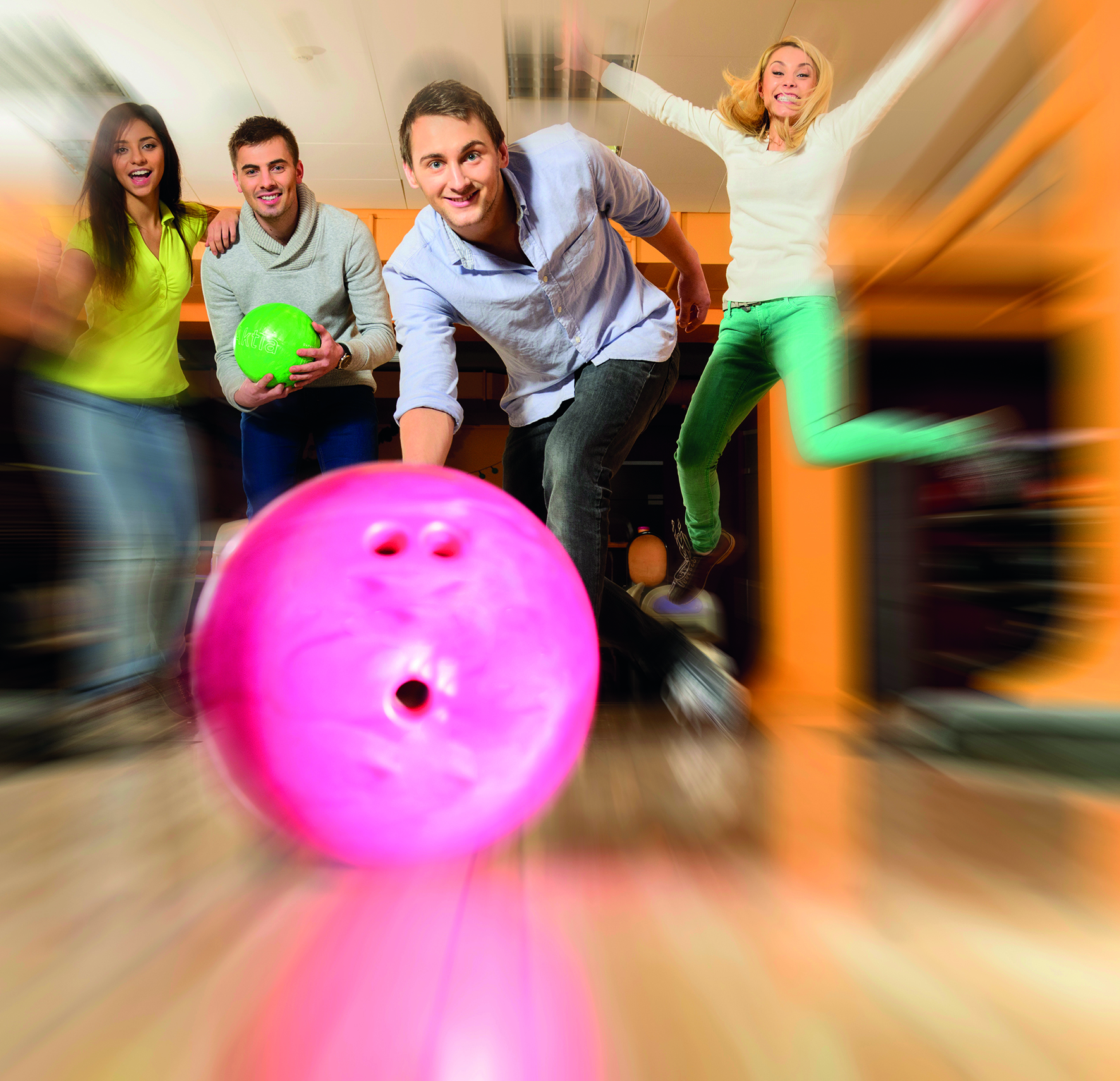 Eine pinke Bowlingkugel wird von einem Mann geworfen. Eine pinke Bowlingkugel wird von einem Mann geworfen.