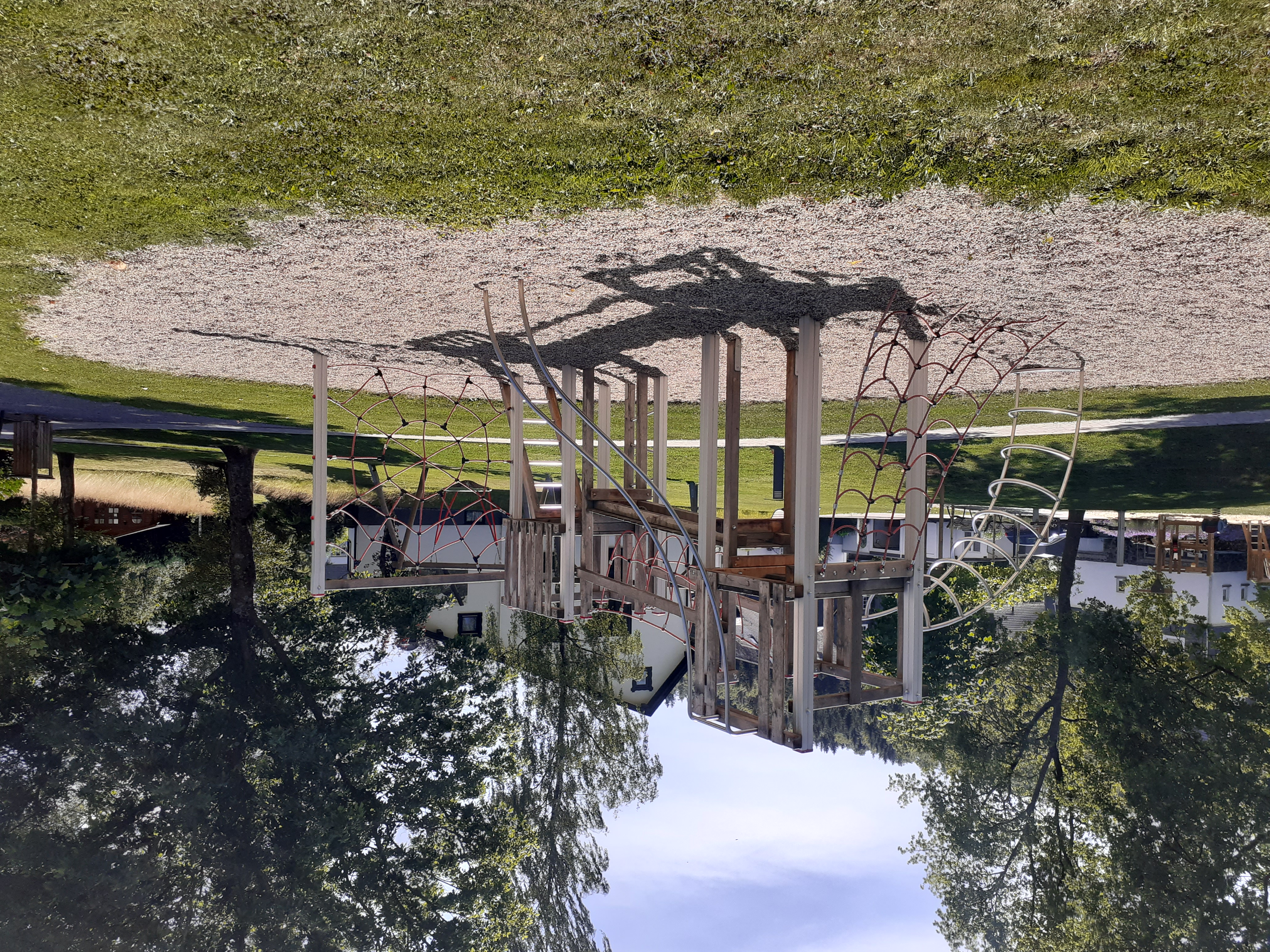 Spielplatz mit Klettergerüst und Sandkasten.