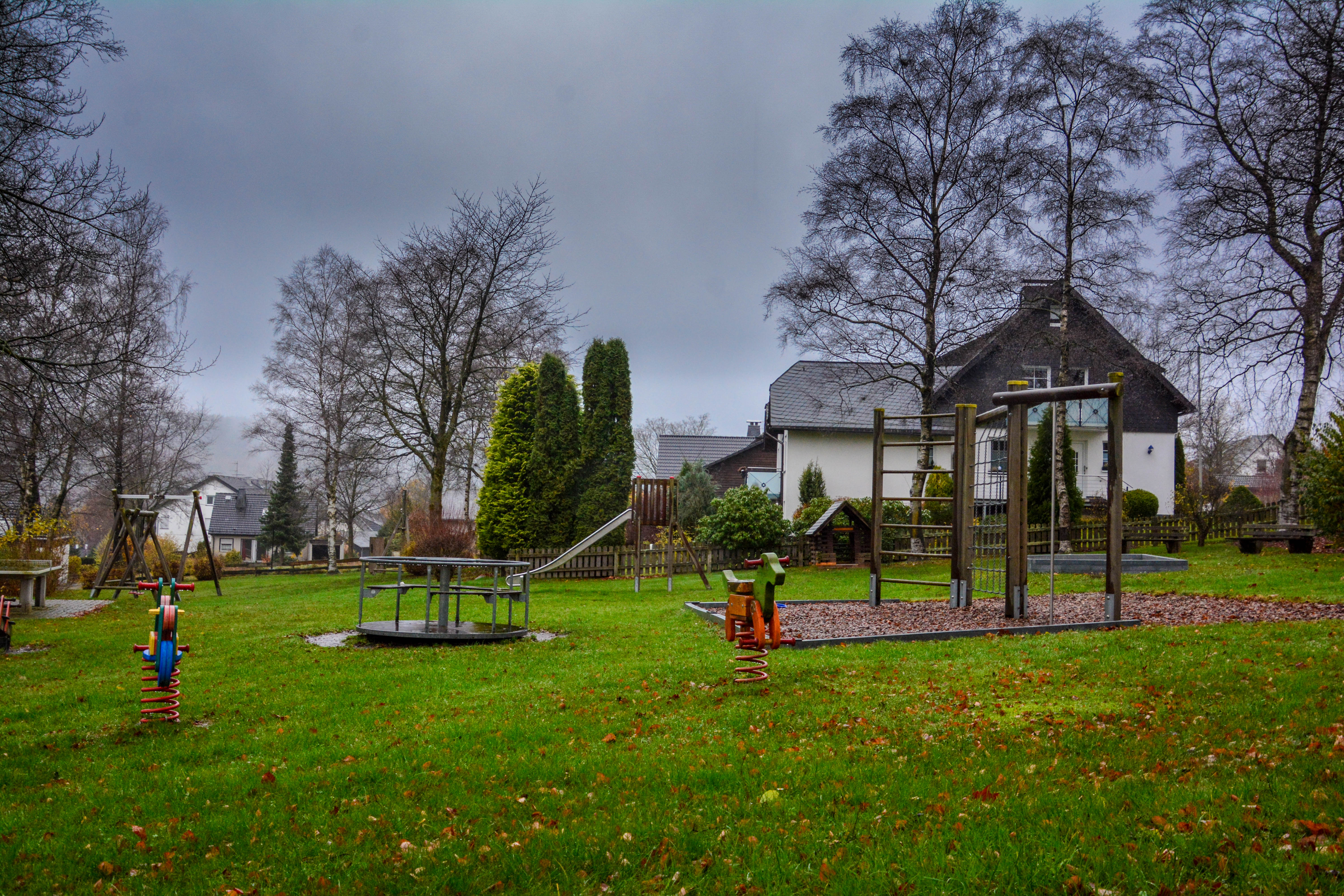 Spielplatz mit Karussell, Schaukel und Wipptieren.
