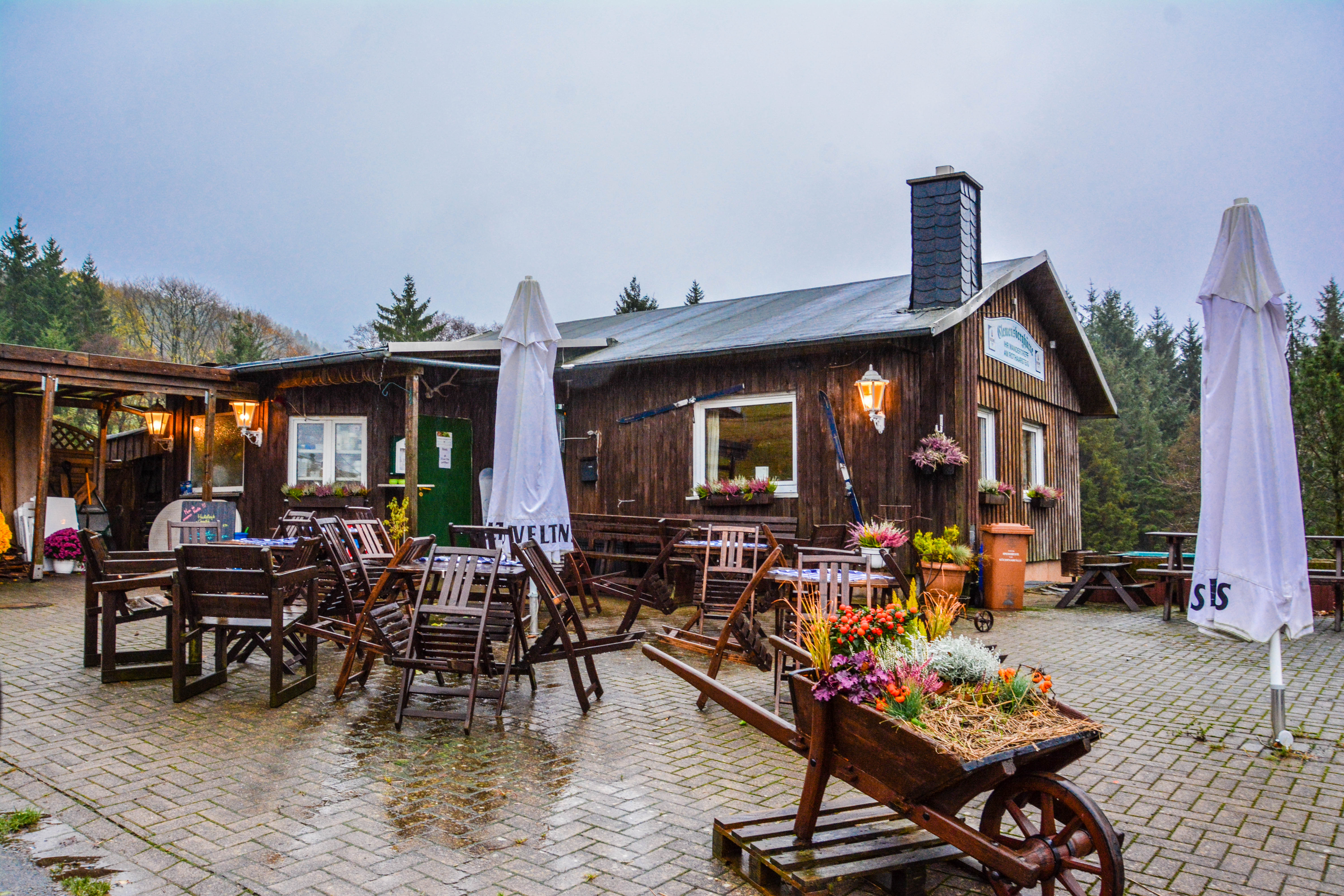 Eine Holzhütte mit Sitzmöglichkeiten im Freien.