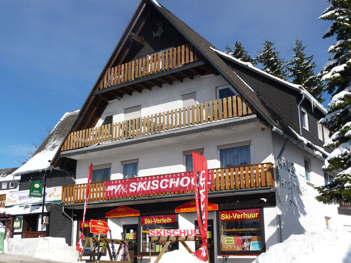 Haus mit der Aufschrift Skischol am Balkon und einem Geschäft im Erdgeschoss. Haus mit der Aufschrift Skischol am Balkon und einem Geschäft im Erdgeschoss.