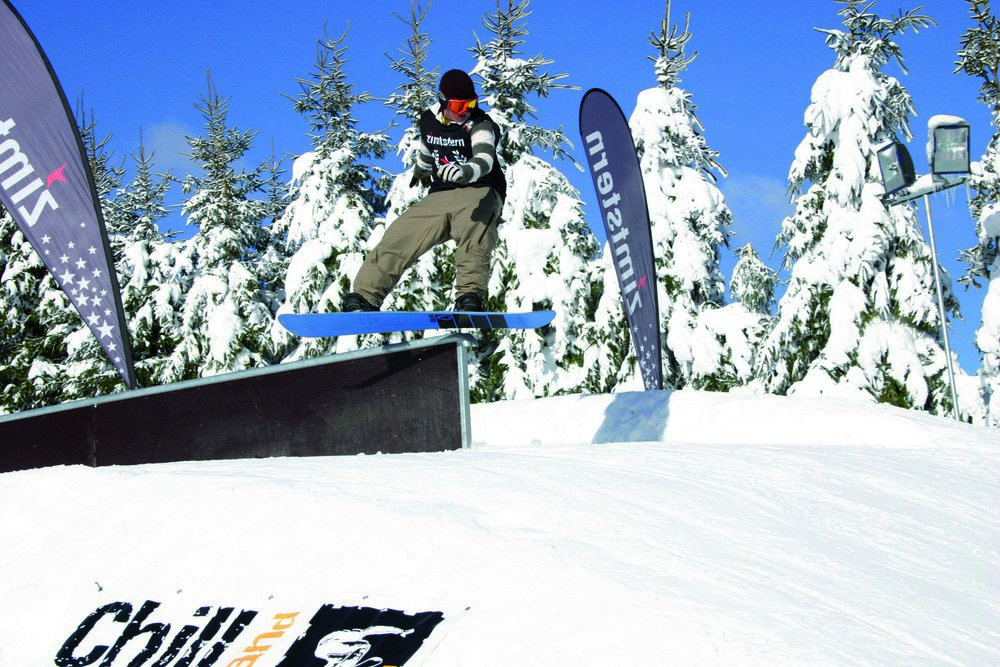 Ein Snowboardfahrer beim Sprung über ein Hindernis.