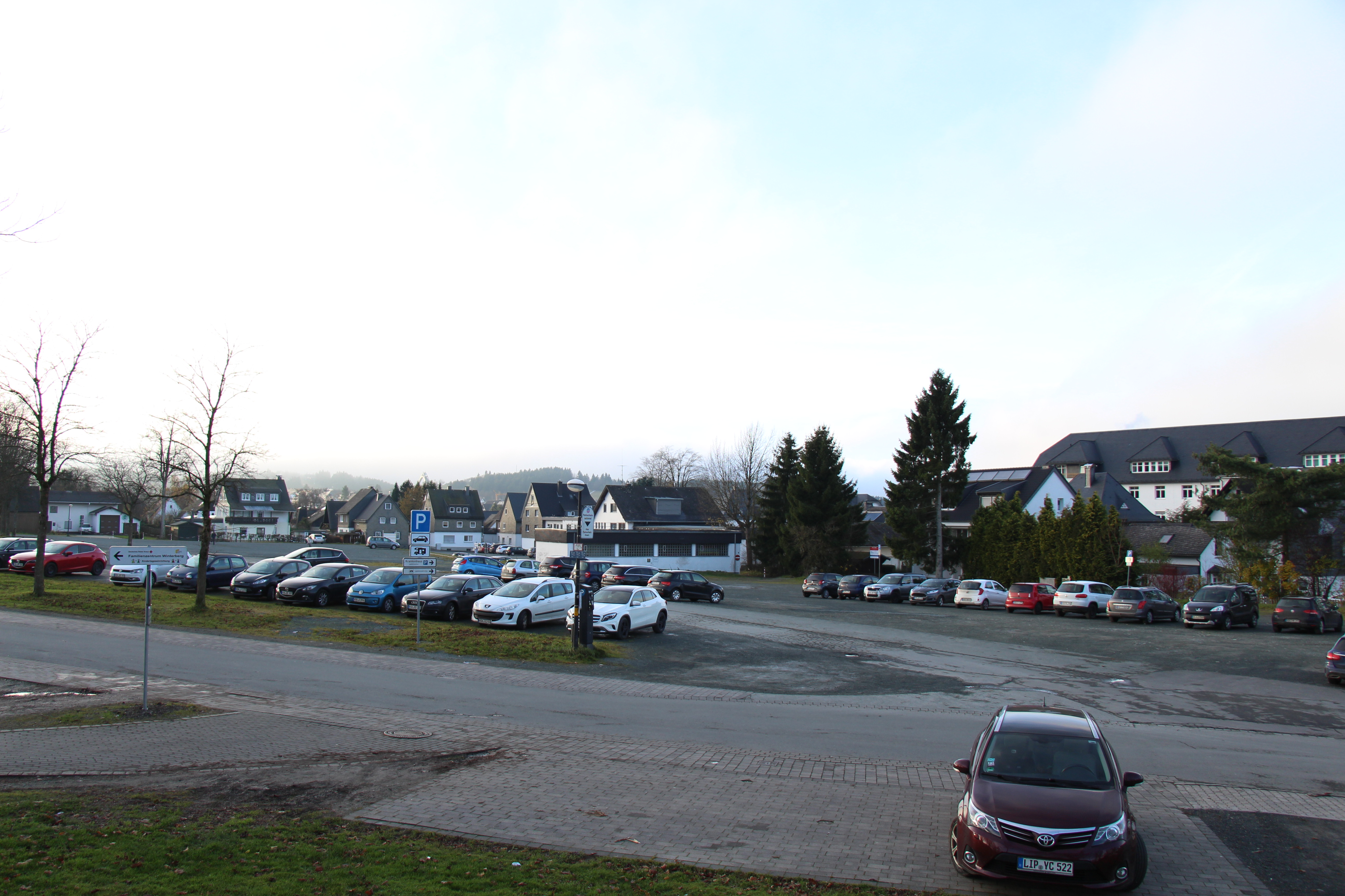Parkplatz mit einigen geparkten Autos.