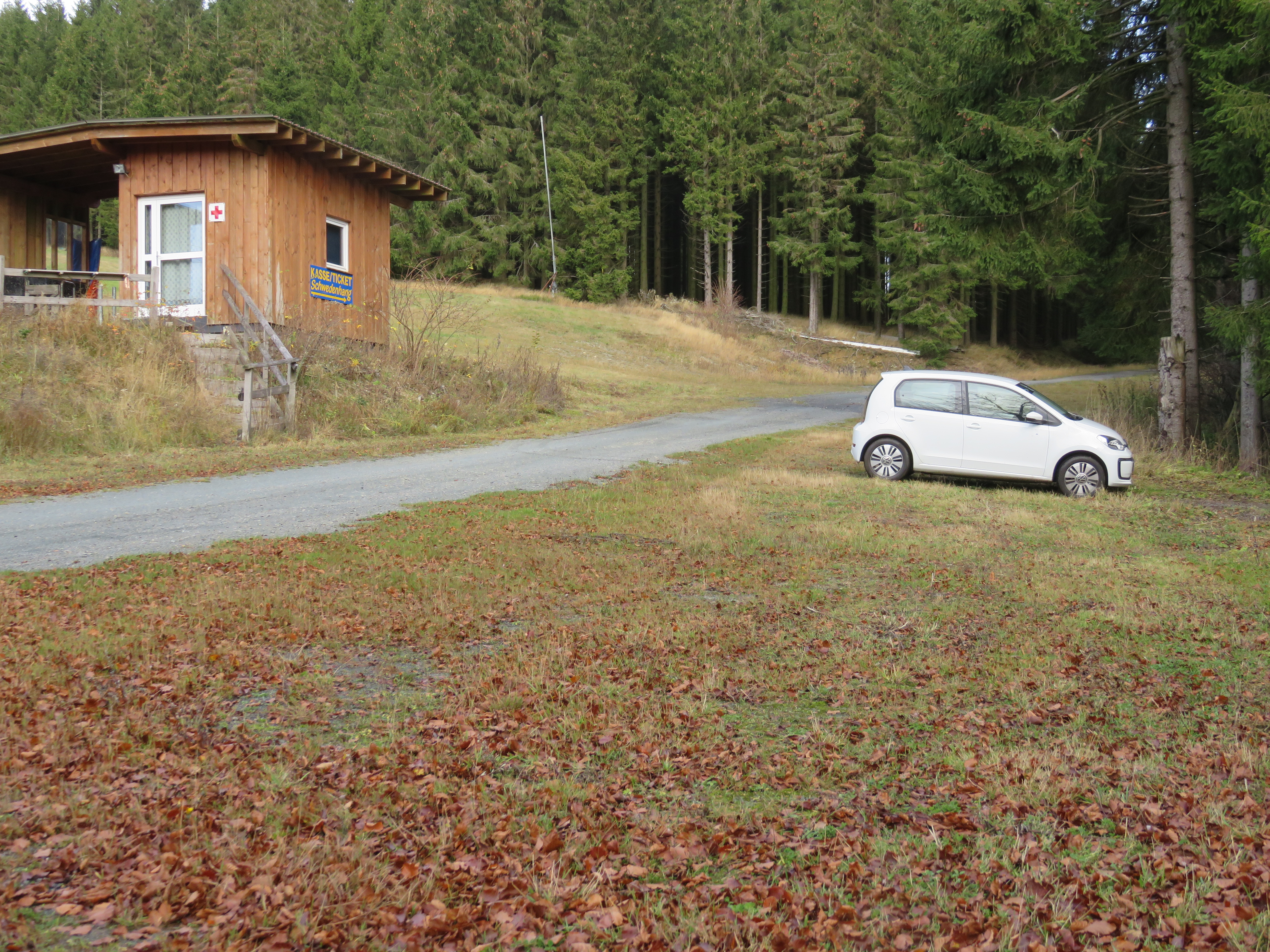 Parkplatz neben einem Weg mit einem weißen geparkten Auto.
