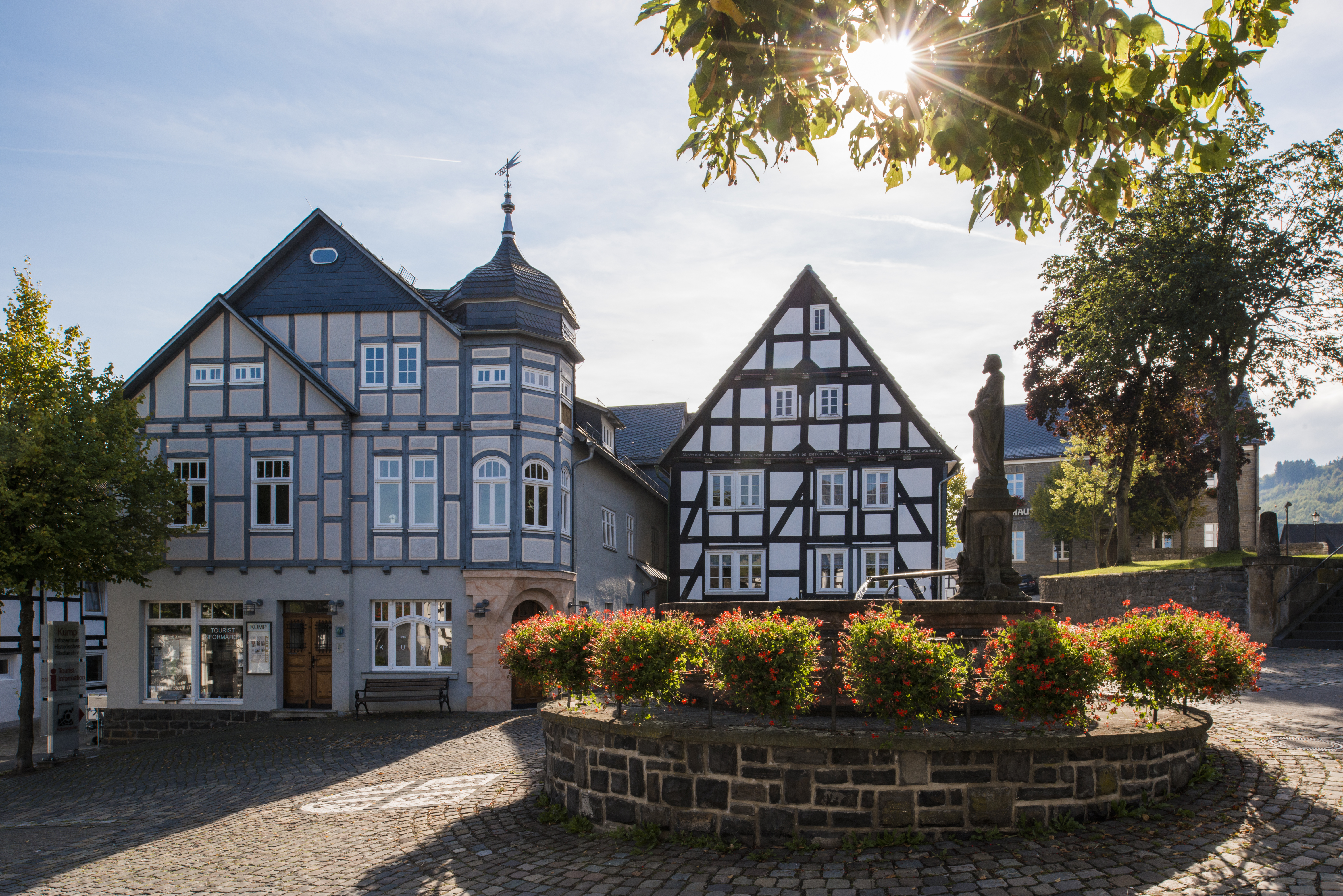 Fachwerkhaus in der Altstadt Hallenberg mit einem Brunnen im Vordergrund.