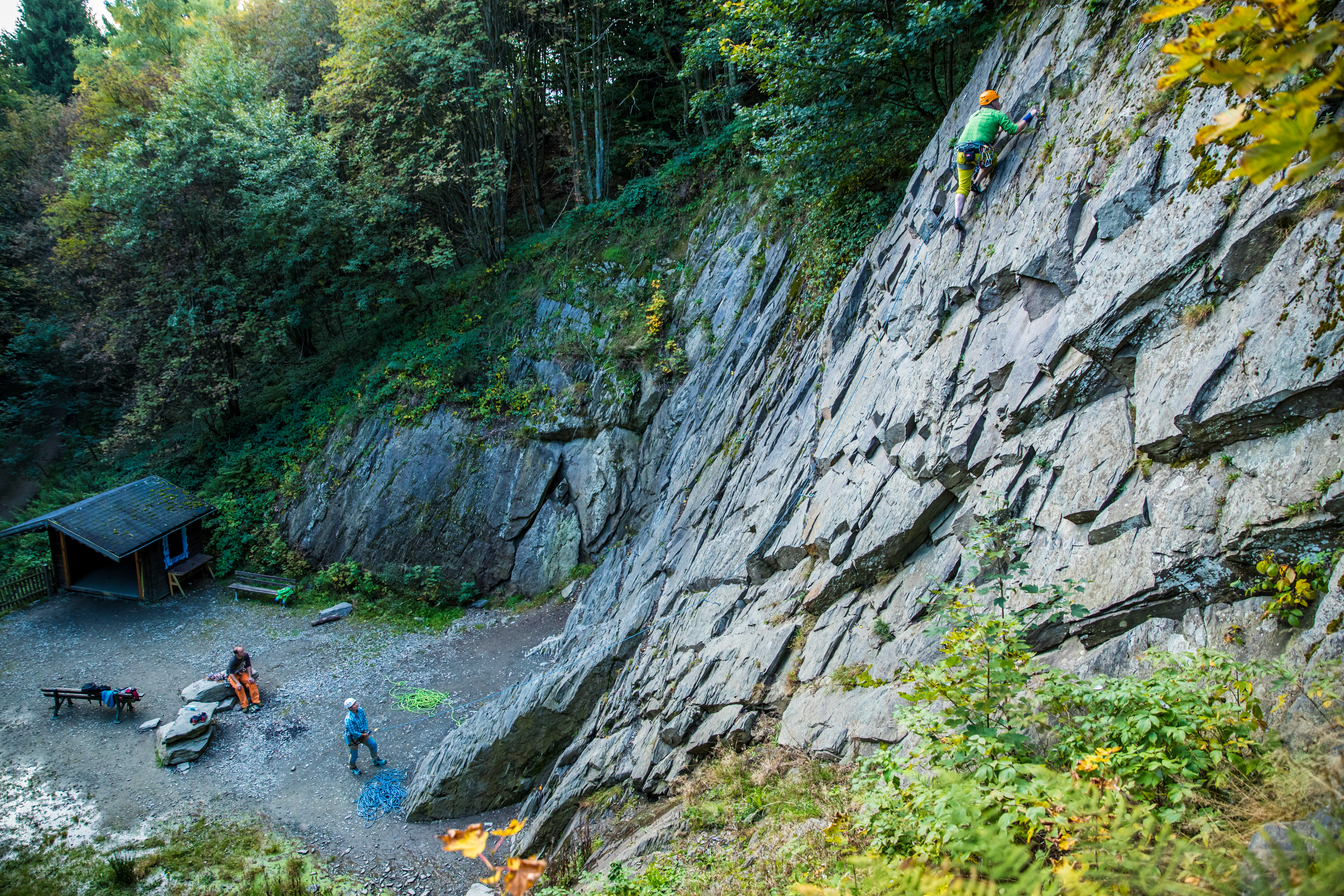 Einige Personen in Kletterausrüstung beim Klettern in der Kletterwand.