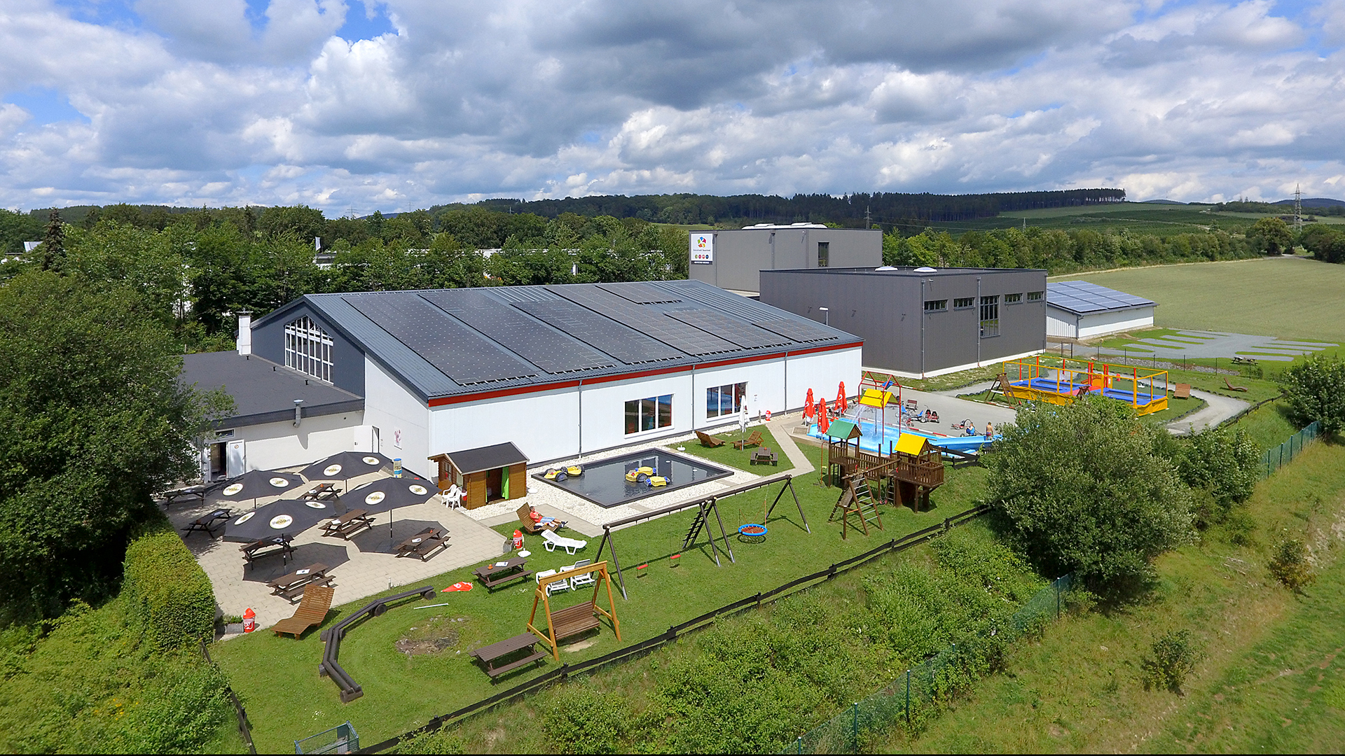 Außenansicht des Gebäudes der Freizeitwelt Sauerland mit Spielmöglichkeiten.