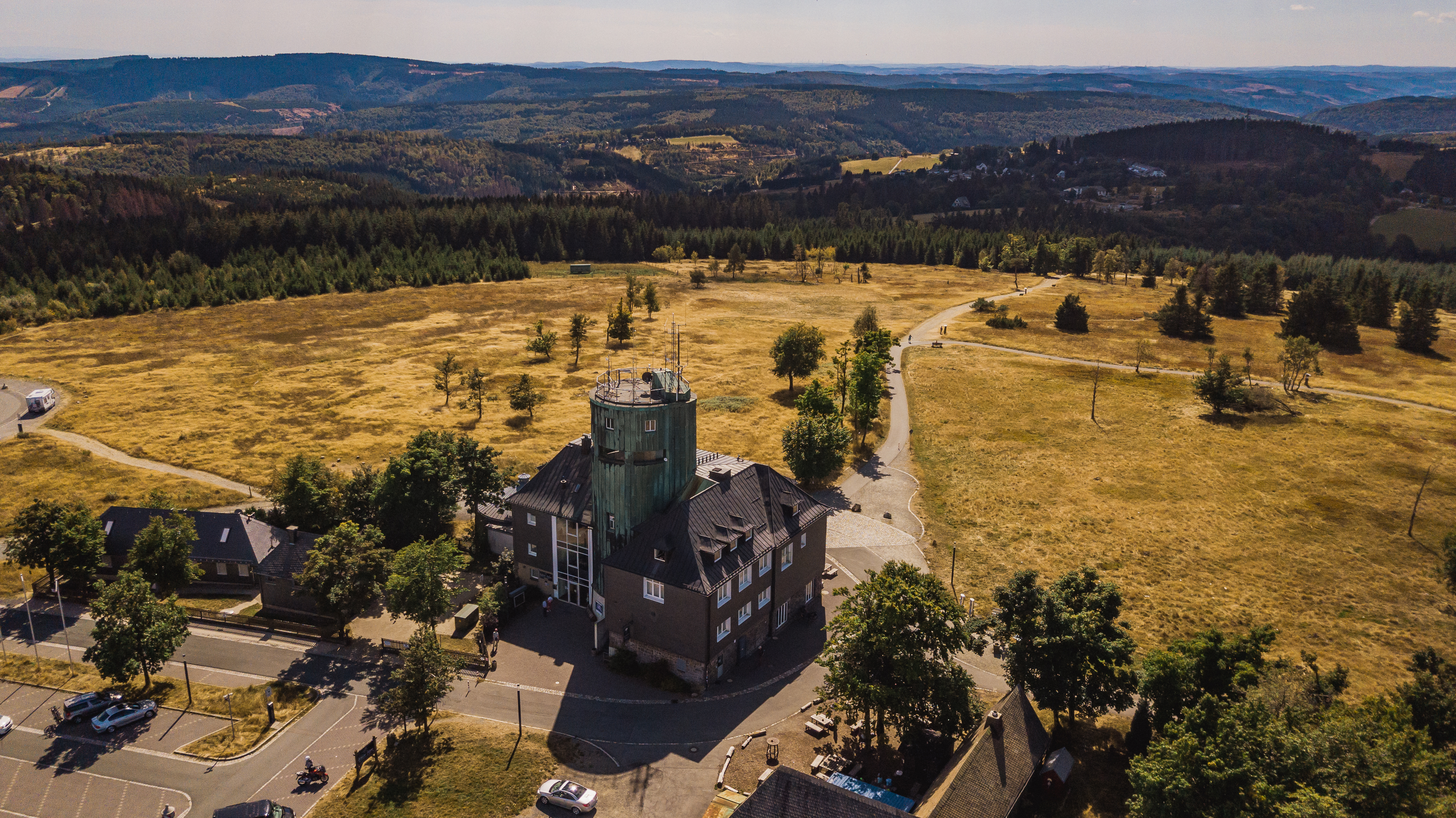 Drohnenaufnahme vom Astenturm mit der Wetterstation umgeben von weiter Heidelandschaft und Wäldern.