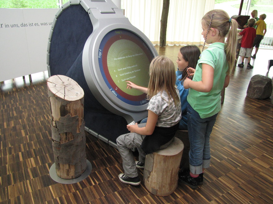 Drei Kinder vor einer digitalen Informationstafel im Natinonalpark Zentrum Kellerwald.