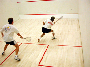 Zwei Personen spielen Squash.