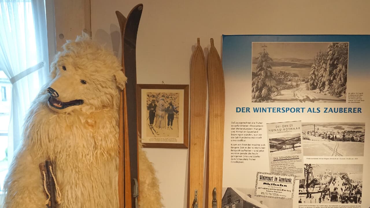 Die Figur eines Eisbären mit Skiern im Arm, daneben eine Informationstafel zum Wintersport. Die Figur eines Eisbären mit Skiern im Arm, daneben eine Informationstafel zum Wintersport.