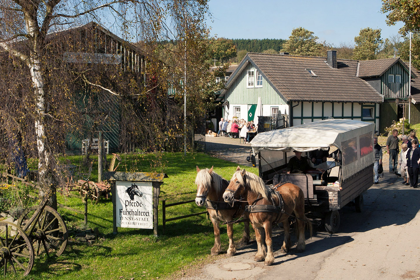 Eine Pferdekutsche mit zwei Pferden vor einem Haus. Eine Pferdekutsche mit zwei Pferden vor einem Haus.