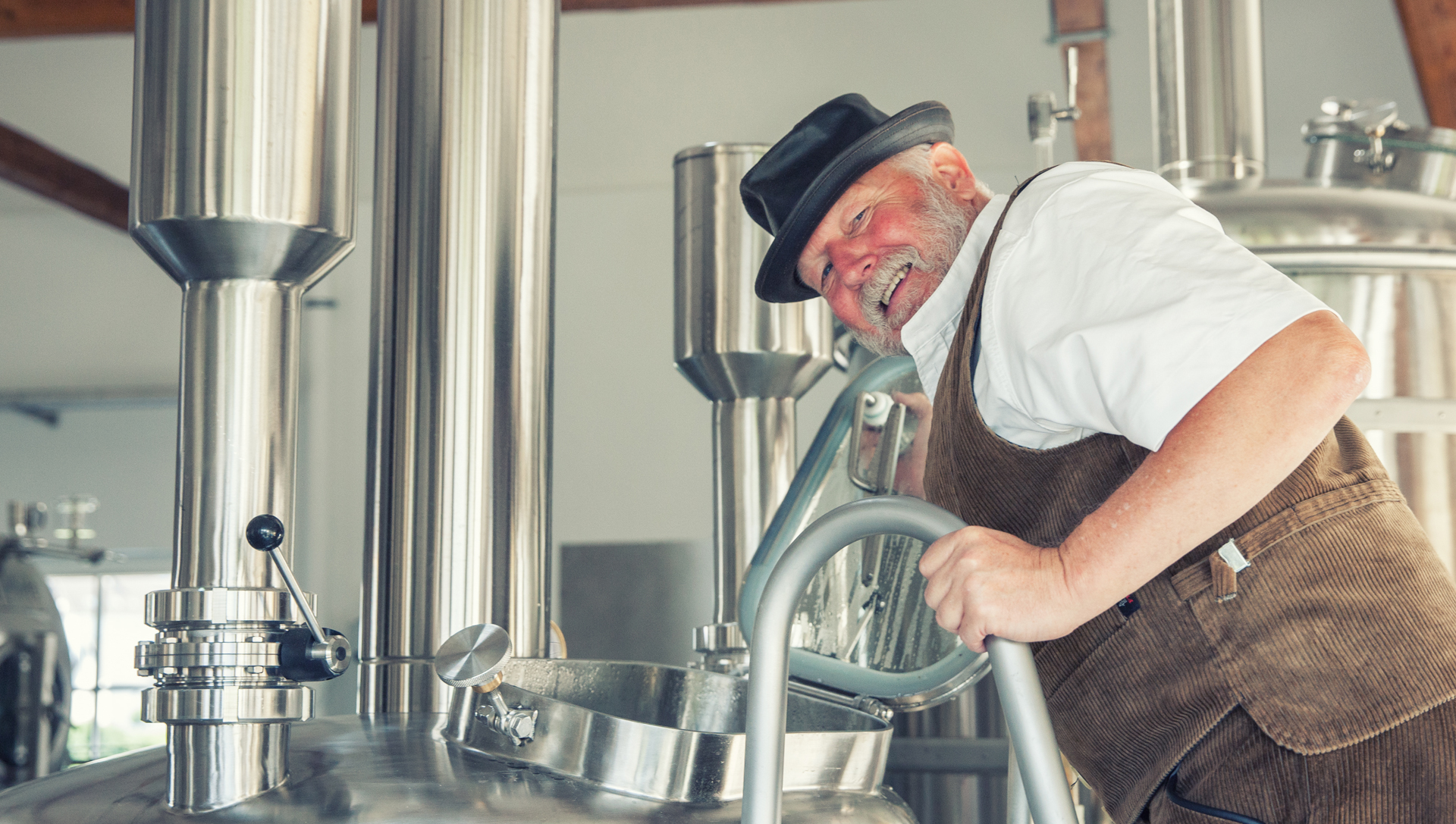 Ein Mann vor einem Tank zum Bier brauen.