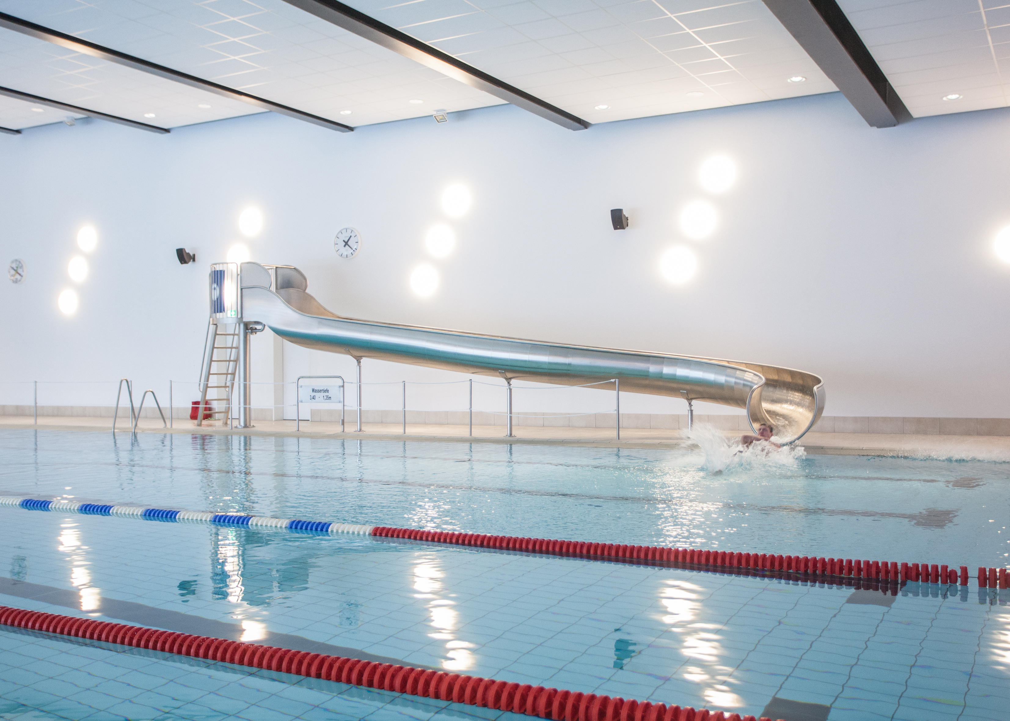 Der Teil eines Hallenbades mit einer Metallrutsche. Der Teil eines Hallenbades mit einer Metallrutsche.