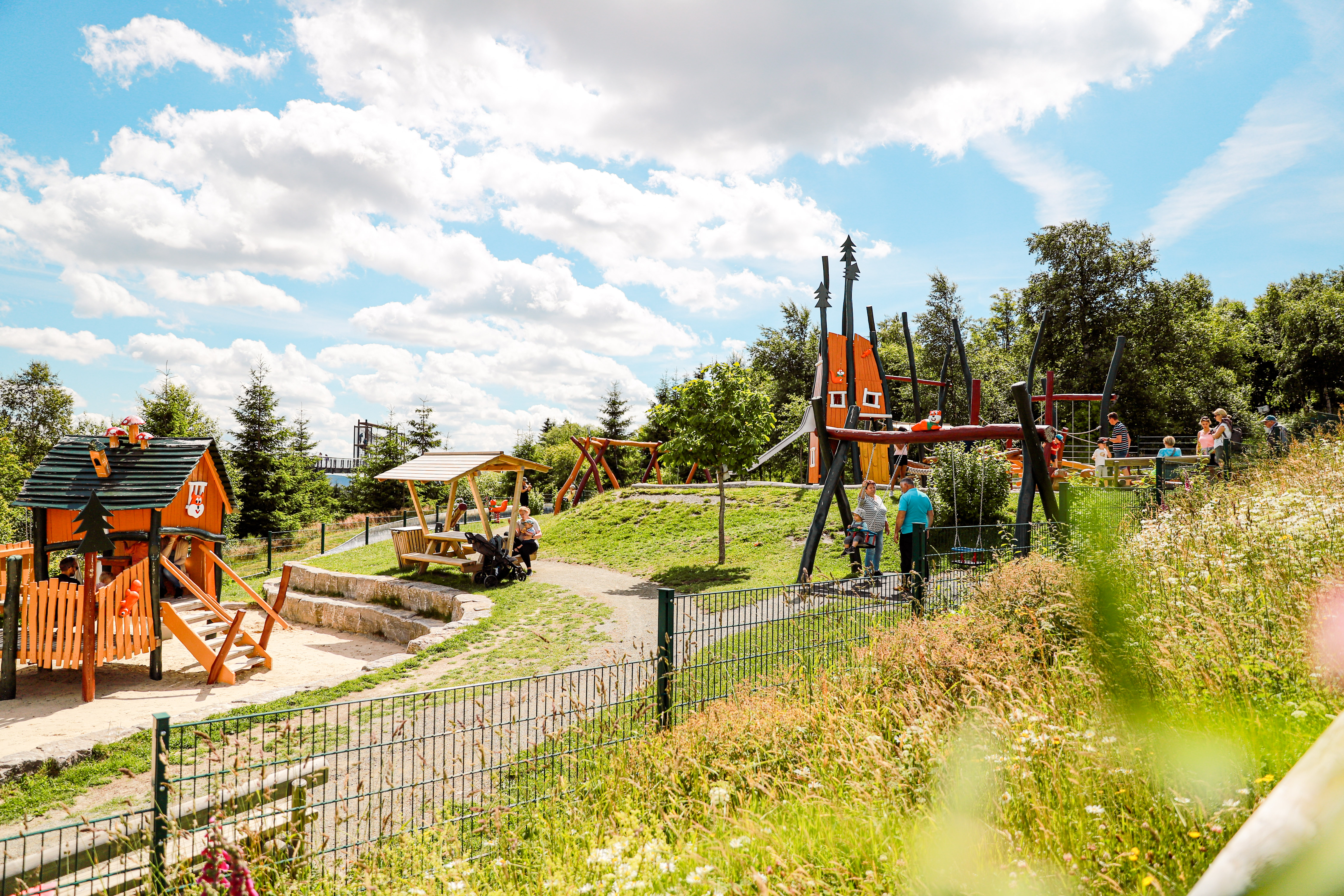 Spielplatz mit Schaukel, Rutsche und Klettergerüst.