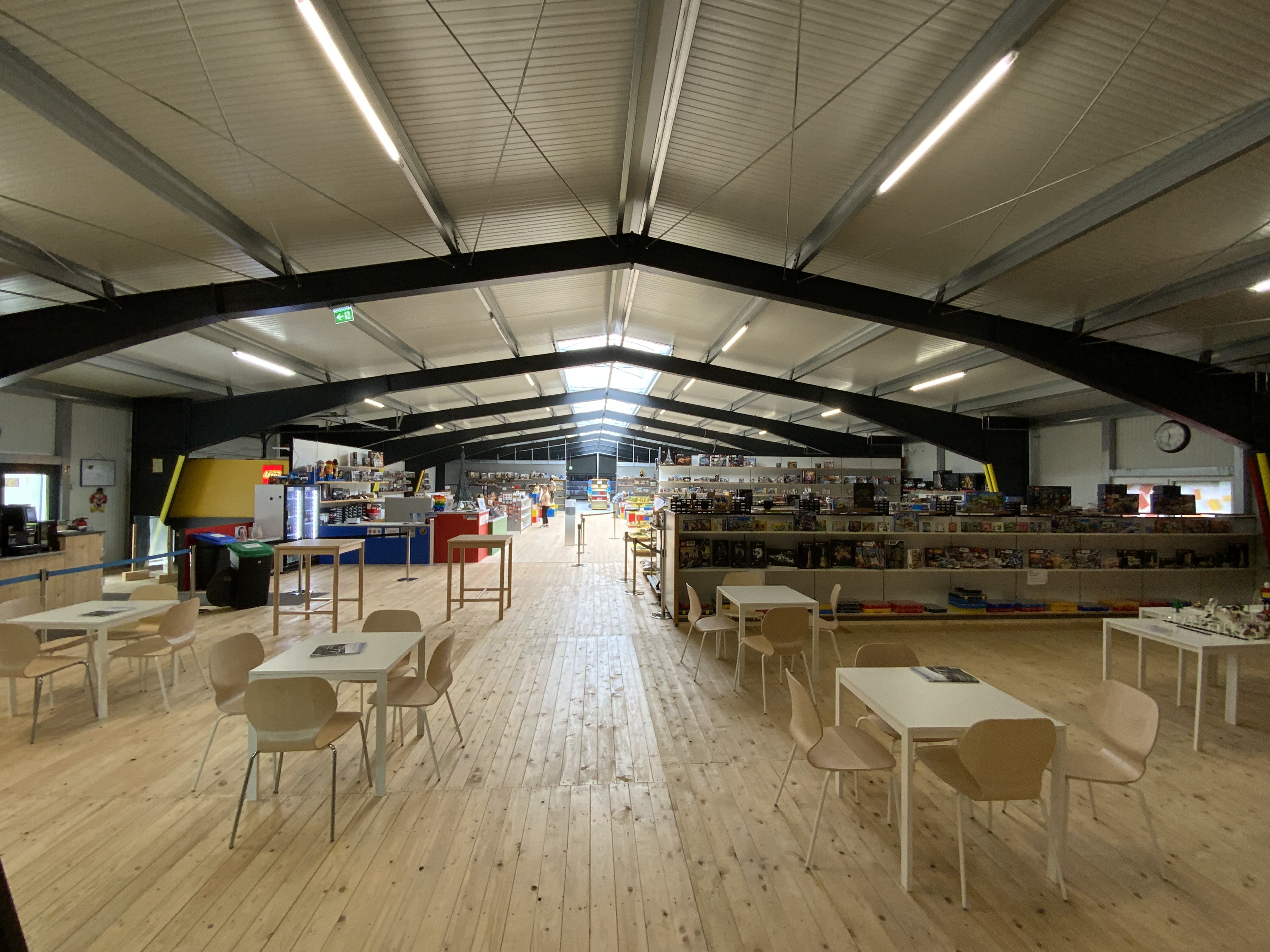 Großer Raum mit Tischen und Stühlen und ausgestellten Legobauten.