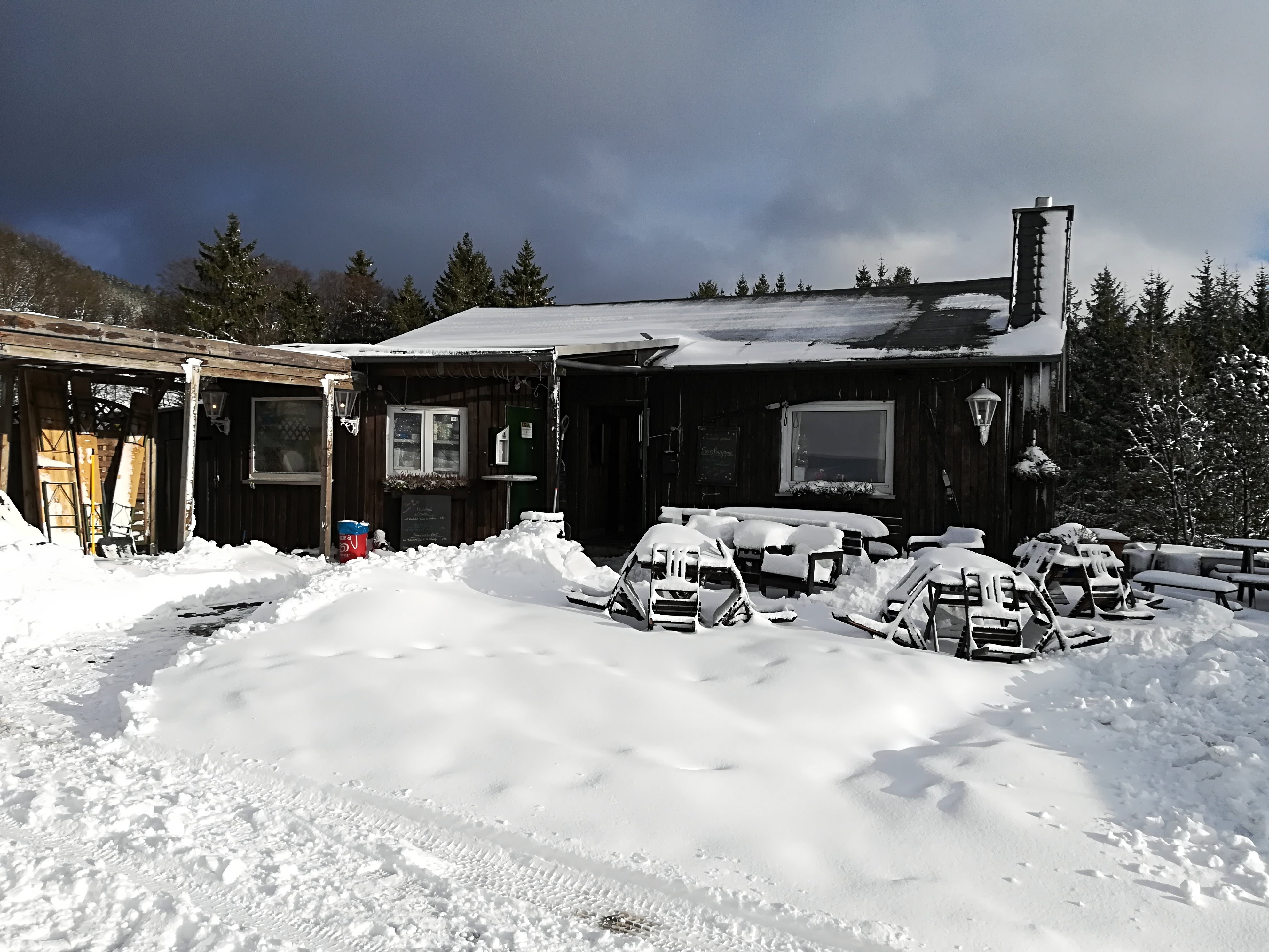 Eine Holzhütte umgeben von Tannen und Schnee. Eine Holzhütte umgeben von Tannen und Schnee.