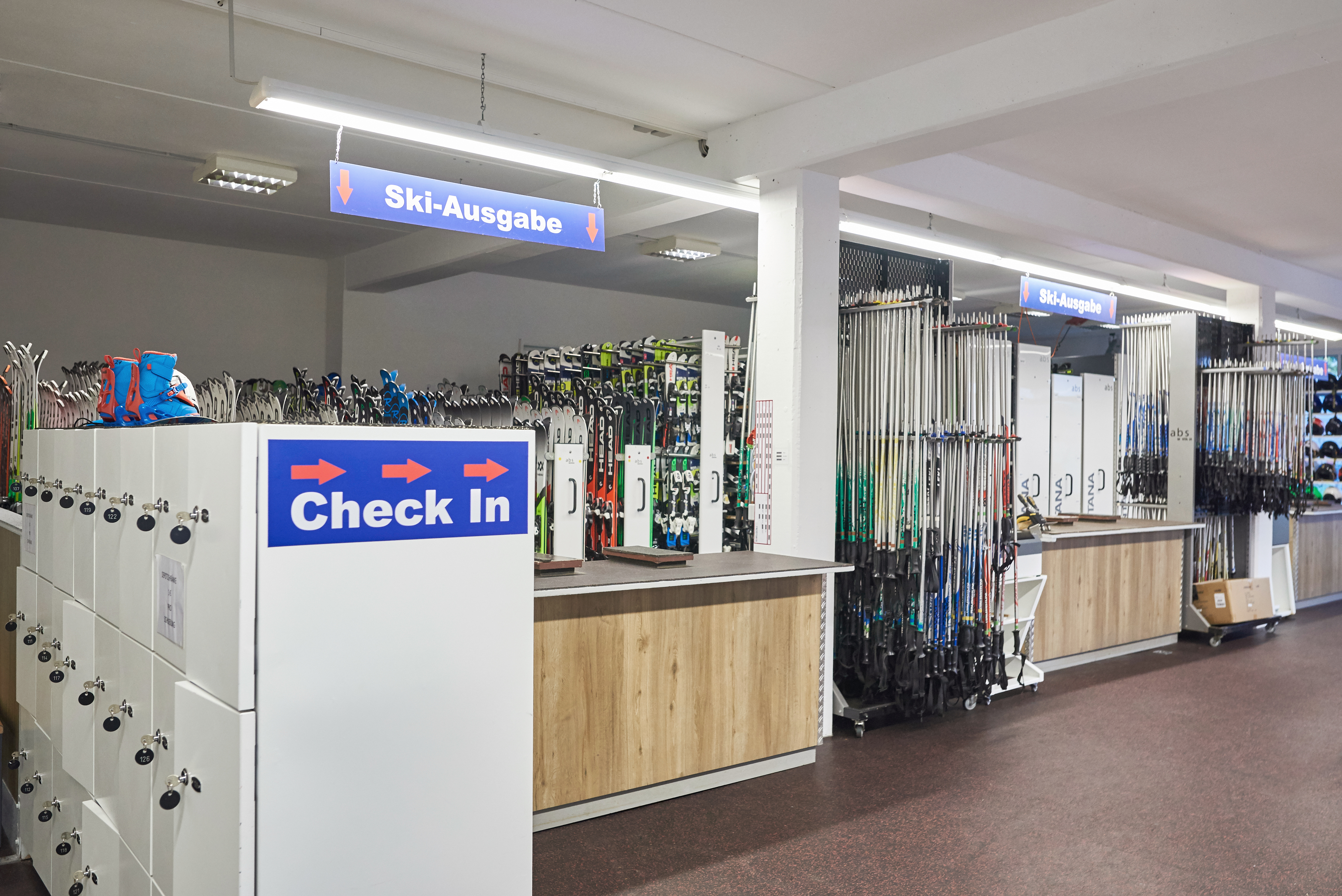 Innenraum eines Skiverleihes mit verschiedener Skiausrüstung.