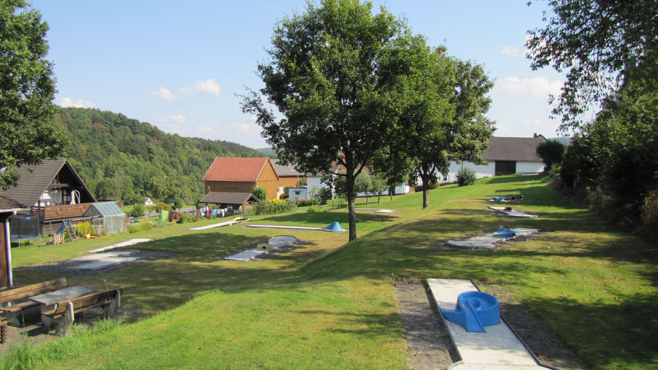 Eine Minigolfanlage mit einigen Wohnhäusern im Hintergrund.