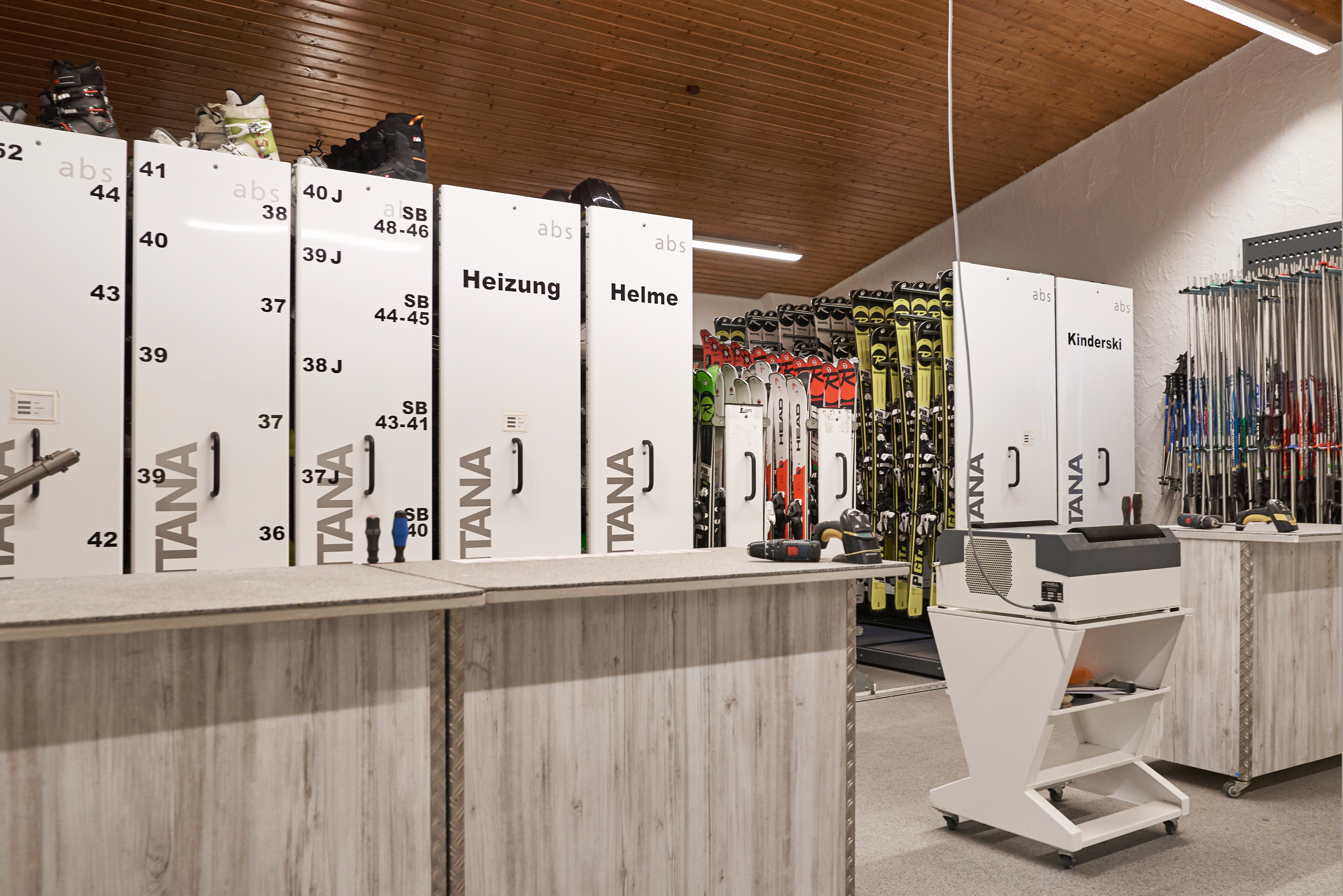 Innenraum eines Skiverleihes mit verschiedener Skiausrüstung.