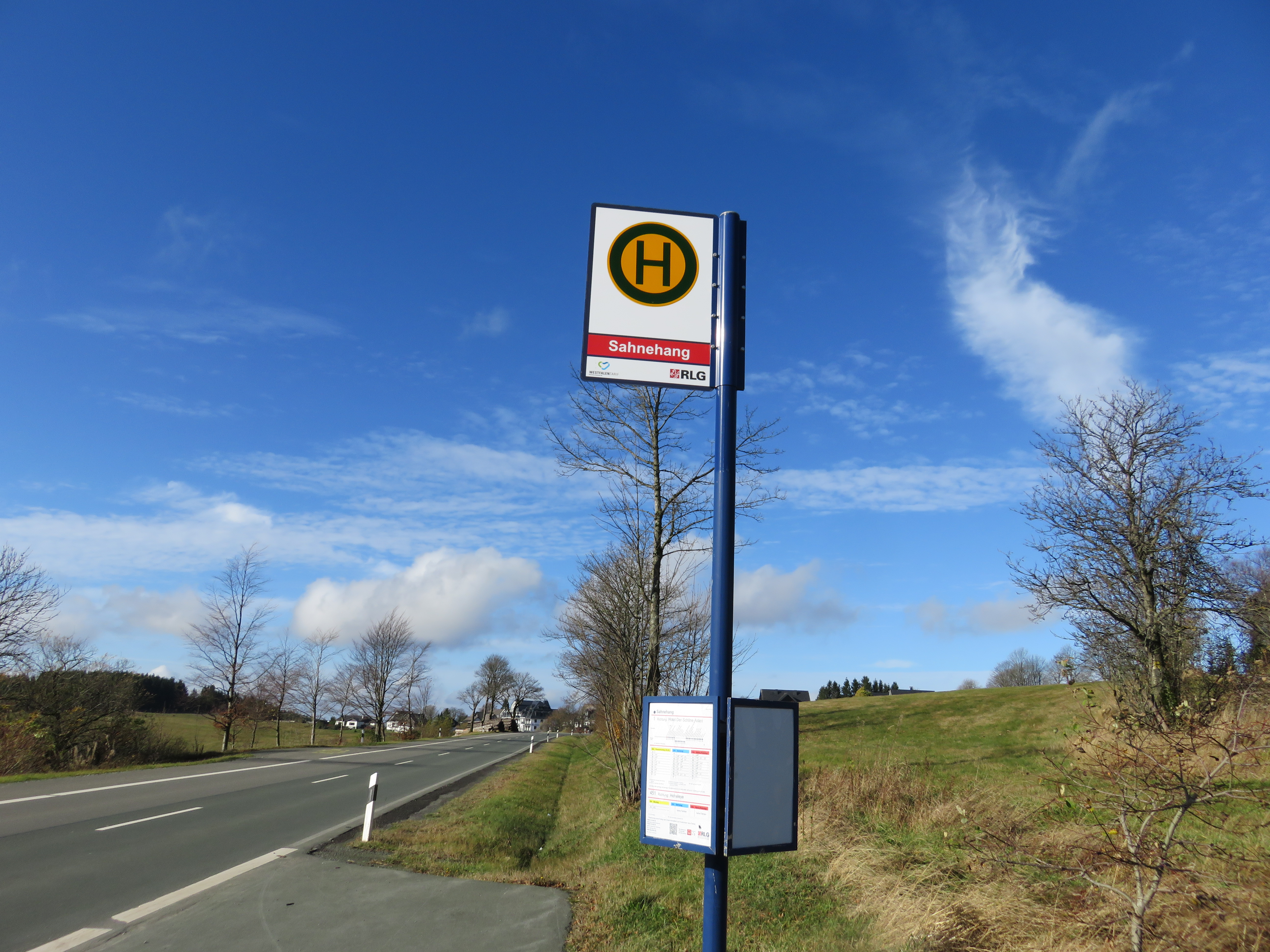 Ein Bushaltestellenschild an einer Straße.