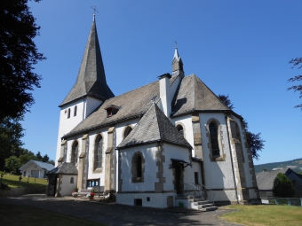 Eine große weiße Kirche mit einigen Türmen vor blauem Himmel.