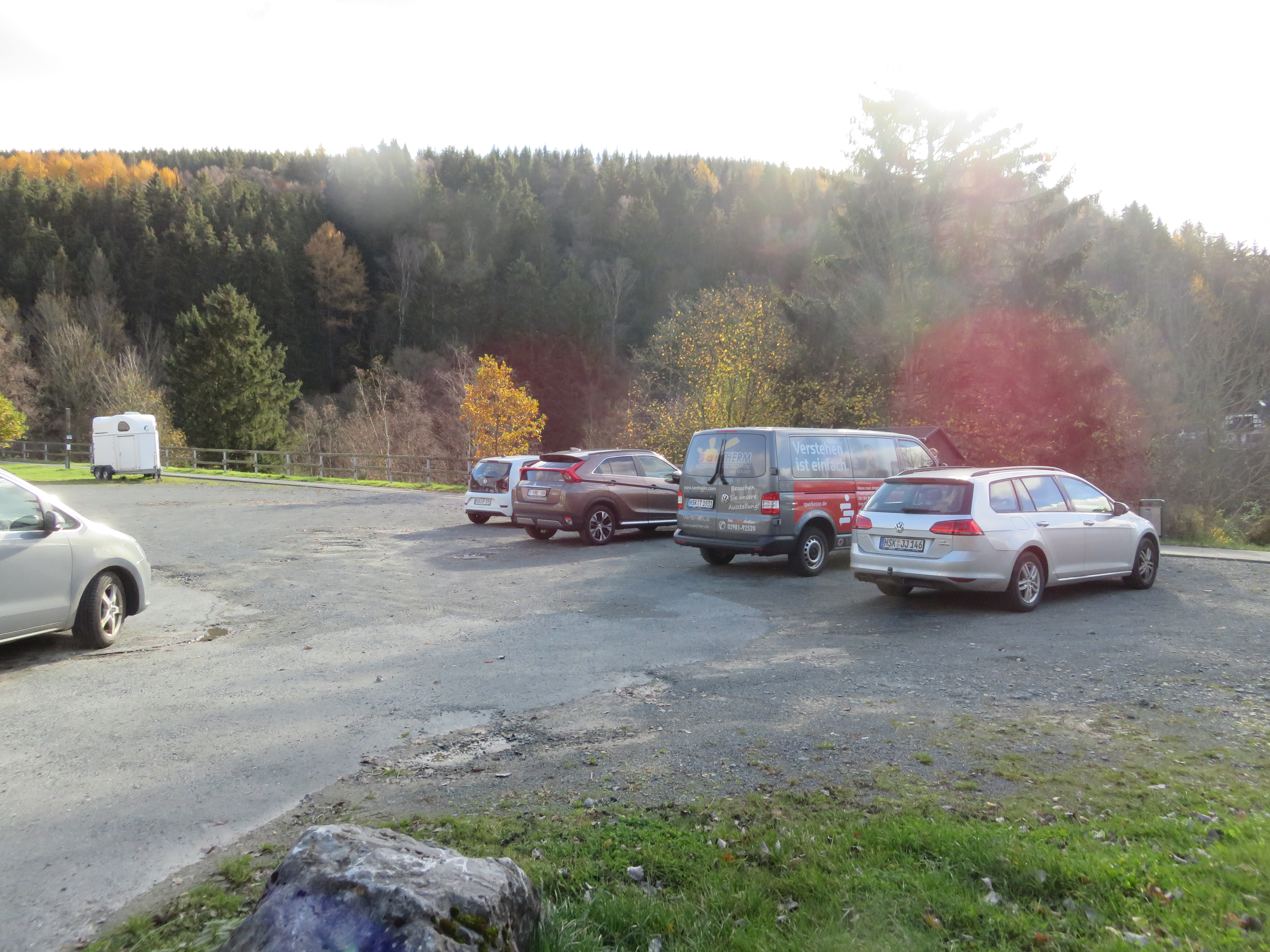 Parkplatz am Feuerwehrhaus in Züschen mit Wald im Hintergrund.